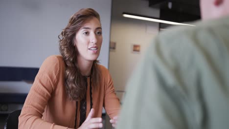 Diverse-male-and-female-colleagues-in-discussion-in-casual-office-meeting