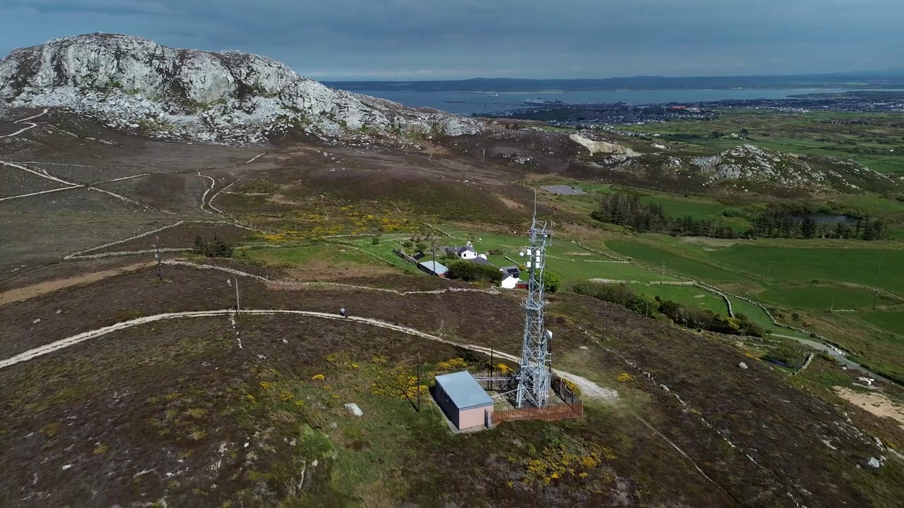 Vetta del monte Holyhead terreni agricoli vista aerea che inquadra un palo/torre di telecomunicazioni per trasmissioni.