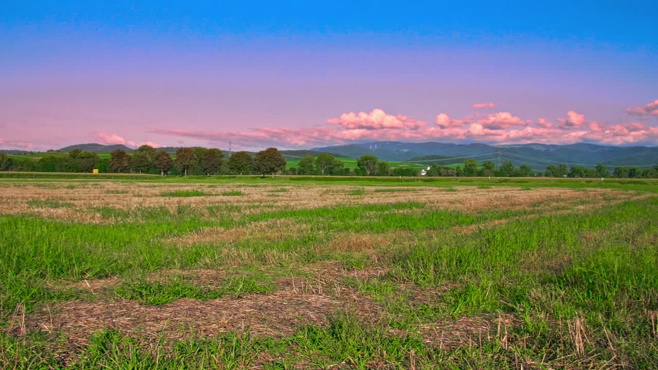 Verde terreno agricolo e aperta campagna sotto un cielo colorato nella Germania meridionale