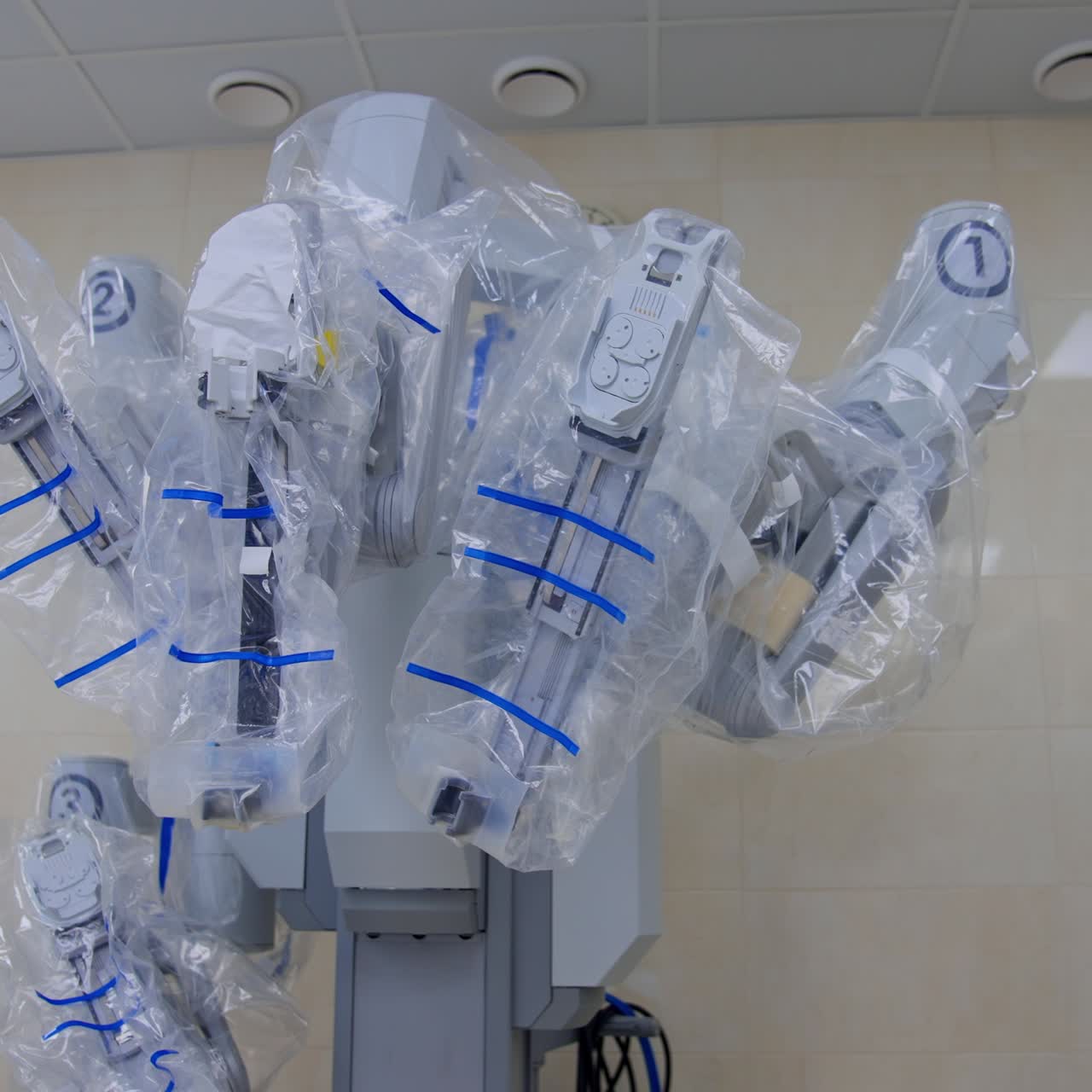 Da Vinci robot standing at the wall of surgical theatre. High precise advanced technological equipment covered in plastic