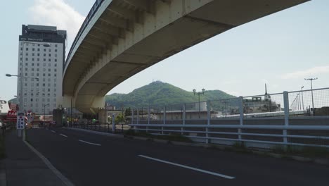 empty road with overpass and view of mount hakodate in distant background