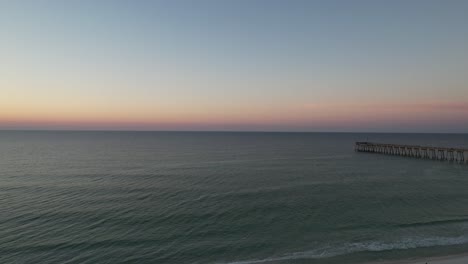 drone flying over a path of sea oats and emerald waters white sands of the gulf of mexico at sunrise summer day