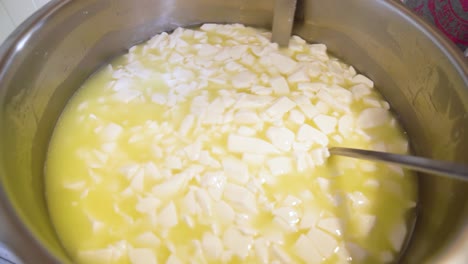 freshly extracted goat cheese curds floating in milk during cheesemaking process
