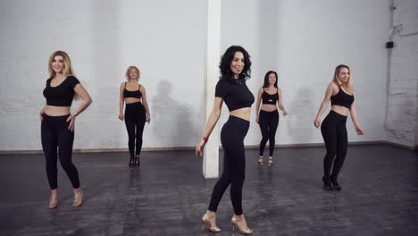 a group of female bachata dancers gathering in the center of ballroom to learn and dance basic moves, steps.