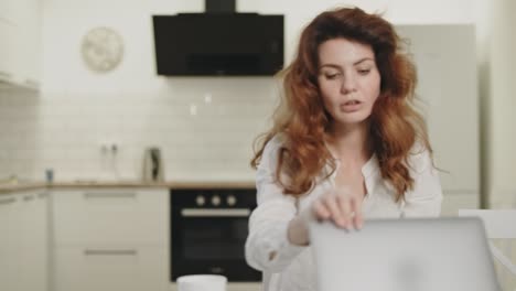 mujer de negocios seria cerrando la computadora en un lugar de trabajo remoto.