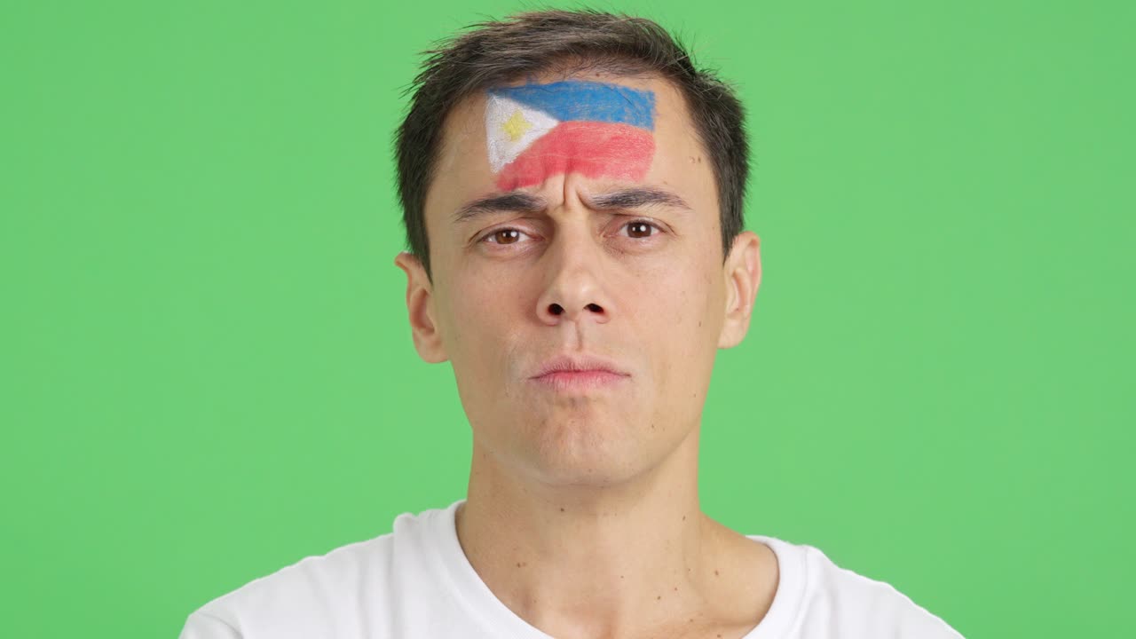 Serious man with a philippine flag painted on the face