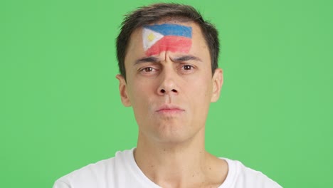 serious man with a philippine flag painted on the face