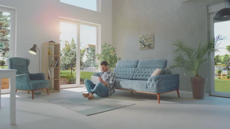 man using laptop sitting on the floor