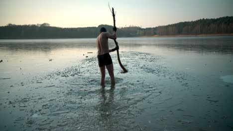 Una-Joven-Ma-Rompiendo-Hielo-En-El-Río-Para-Nadar-Con-La-Ayuda-De-La-Madera