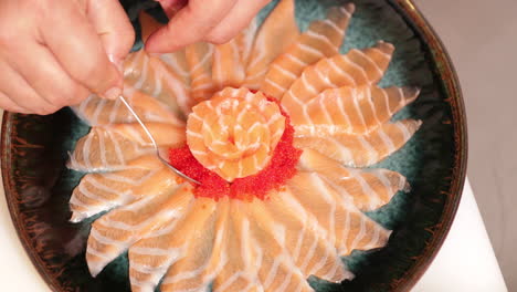 Garnishing-delicious-red-caviar-on-fresh-tuna-slices---Kabuki-sushi-Japan--close-up