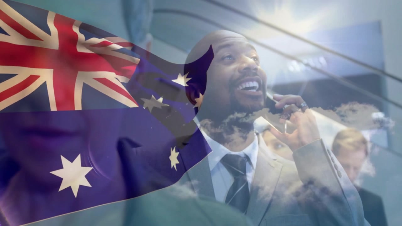Bandera australiana ondeando mientras un hombre de traje contesta una llamada entrante para una reunión de negocios en una escalera mecánica.