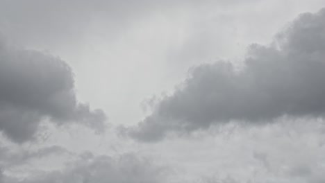 dark grey clouds gather fast in sky, forming rain clouds in moody time lapse sky