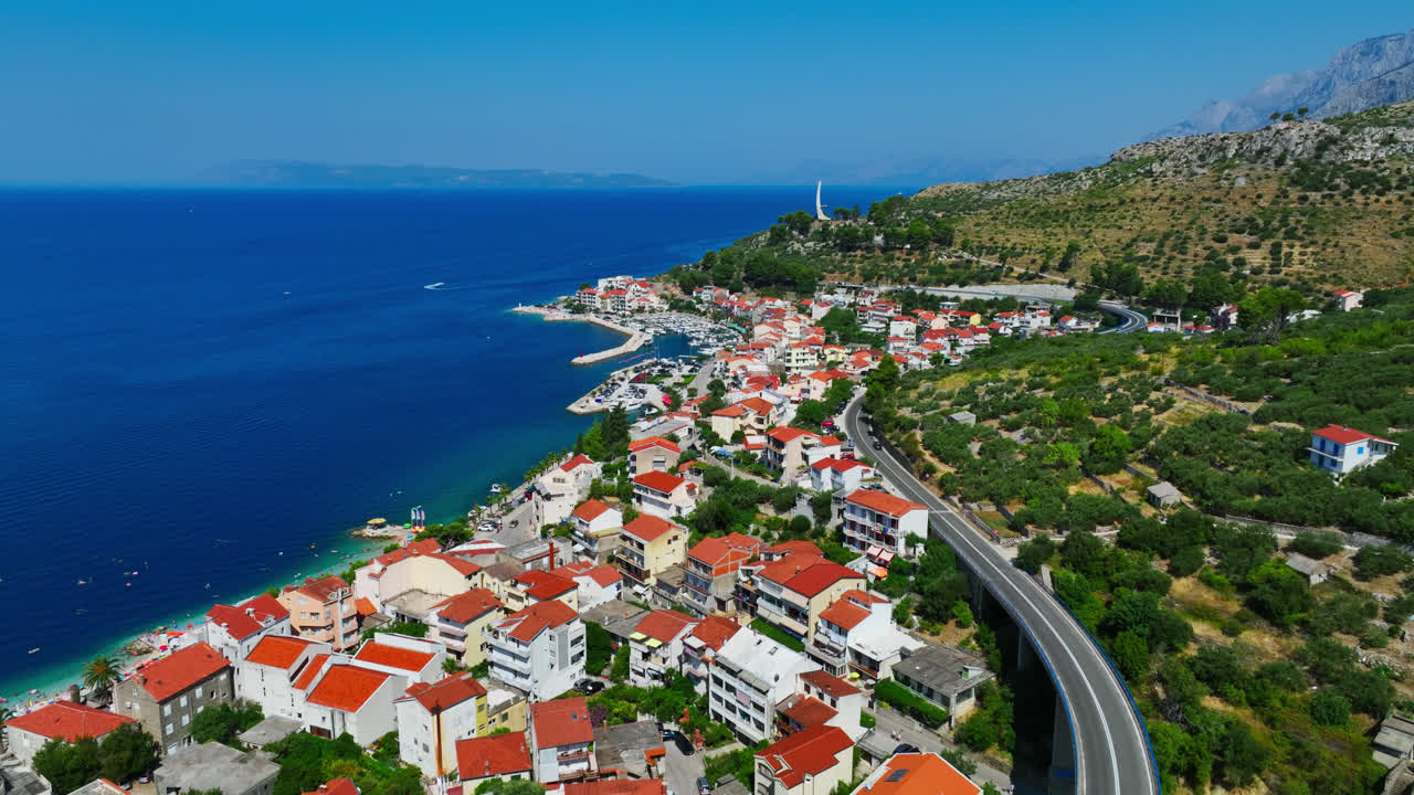 크로아티아 마카르스카 리비에라에서 여름날, 포드고라 마을 위를 돌고 있는 드론