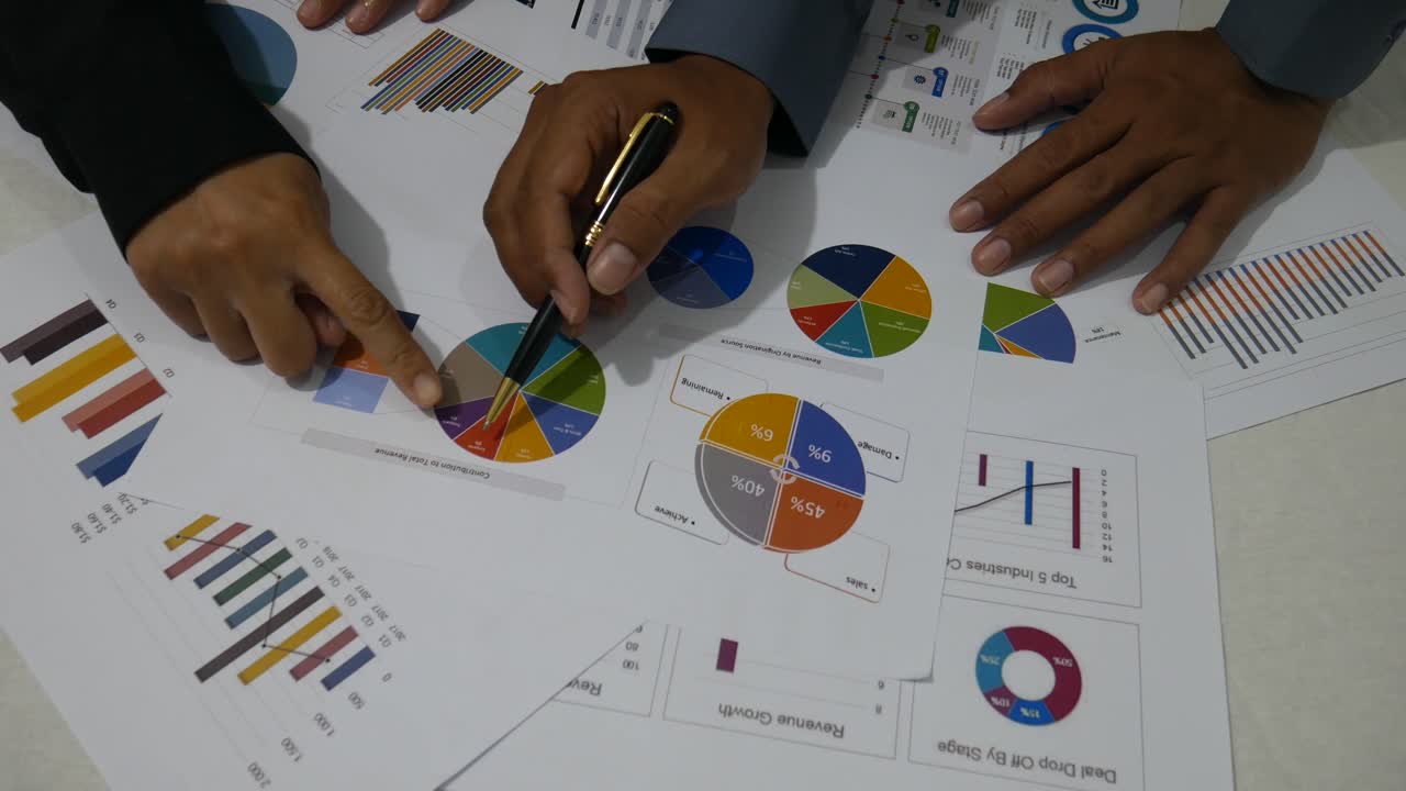 Two business people discussing their company chart in a rather dark room