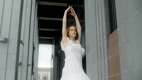 woman in white dress posing in front of a building