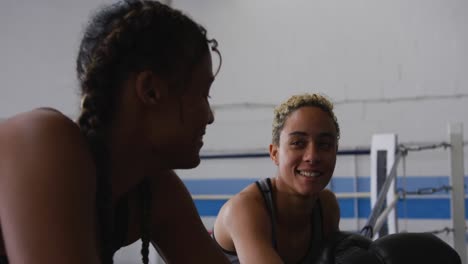 two mixed race women discussing in boxing ring