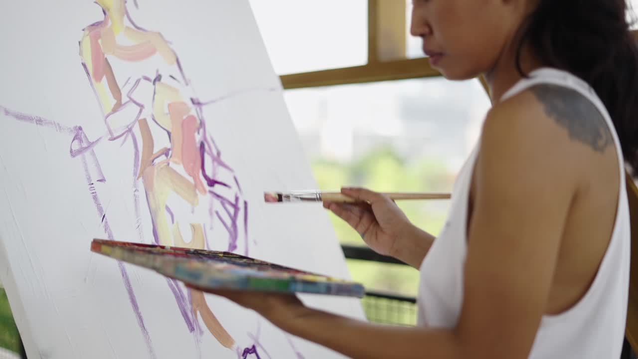 Artist painting an abstract figure on canvas