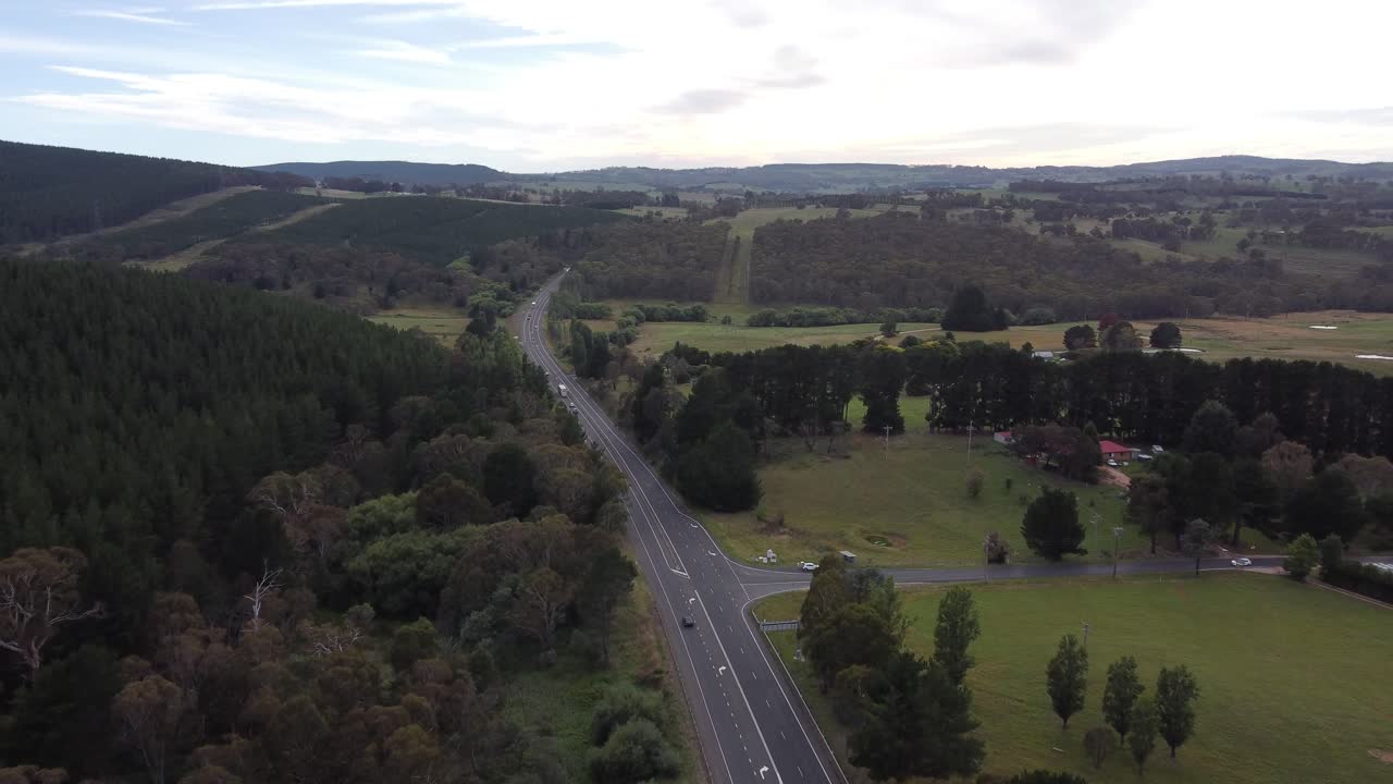 drone volando sobre una carretera rural que se acerca a una propiedad rural en australia