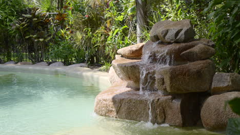 running water into over rock into outdoor pool rock fountain
tropical garden