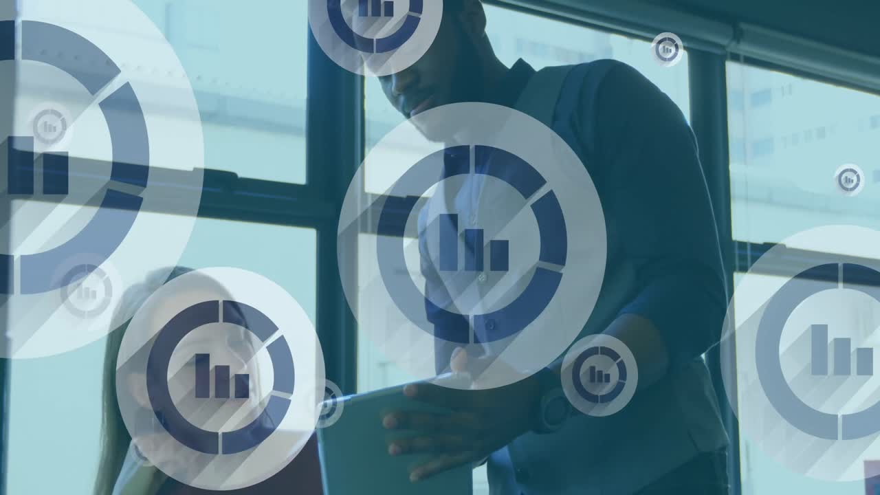 Animation of bar graph icons floating over diverse man and woman discussing over a tablet at office