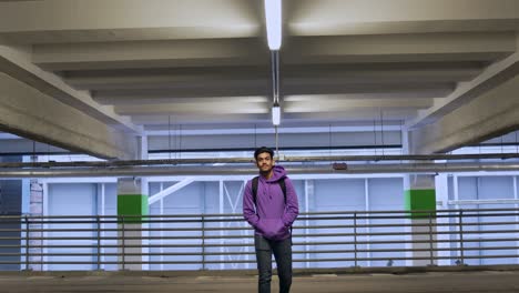 young sri lankan man approaching in slow motion towards the camera in a subway parking garage