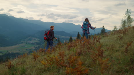 backpacking couple climb mountains. two hikers walk together on travel activity.