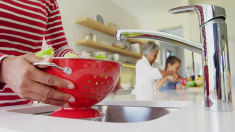 Woman-washing-vegetables-in-kitchen-4k