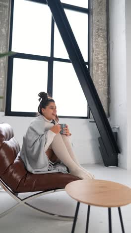 woman relaxing in a chair with a warm drink