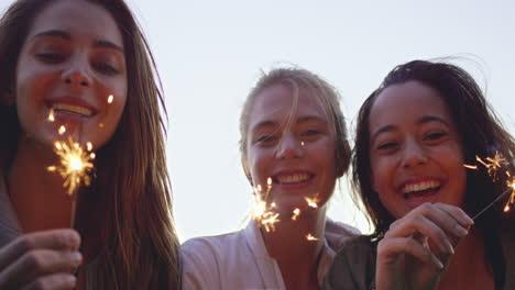 adolescentes celebrando y riendo con bengalas brillantes.