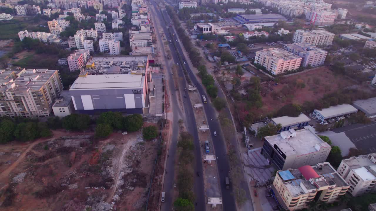 national highway 44 with service road, under Under construction flyover and apartments at suchitra, hyderabad, telangana, india. day time, push in, tilt up, drone shot, 4k.