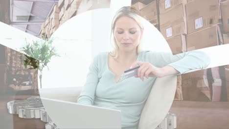 Animation-of-shapes-and-warehouse-over-caucasian-woman-using-laptop-for-online-shopping