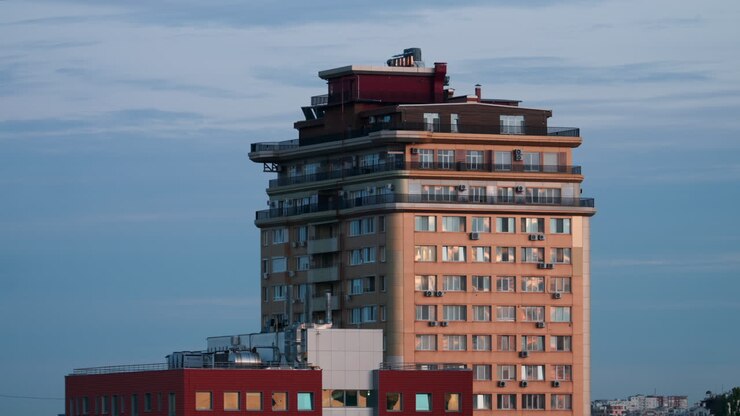 Torre residenziale urbana con riflessi di luce calda al tramonto