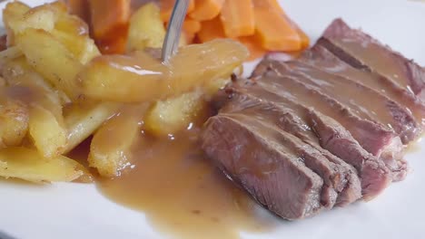 cierre el control deslizante en cámara lenta de comer papas fritas y bistec con un tenedor