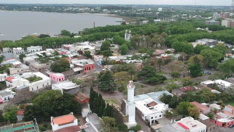 Vista-Panorámica-Del-Antiguo-Faro-En-Un-Pequeño-Pueblo-En-La-Colonia-Del-Sacramento,-Uruguay---Retroceso-Aéreo