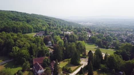 drone shot over trees and building in riehen, switzerland