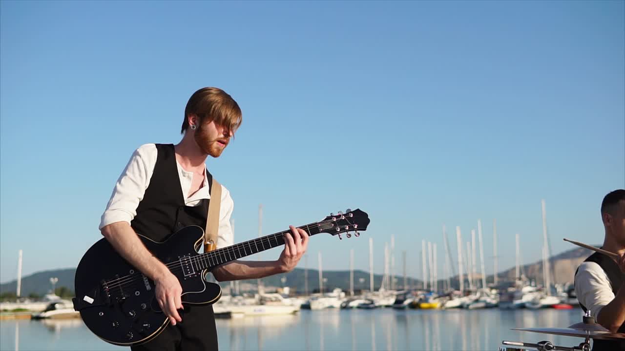 Man Playing Guitar by the Harbor