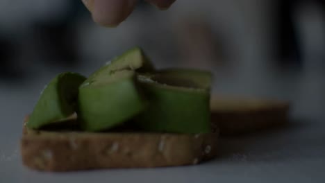 Poniendo-Un-Poco-De-Sal-Y-Exprimiendo-Un-Limón-Sobre-La-Tostada-De-Aguacate-Recién-Hecha