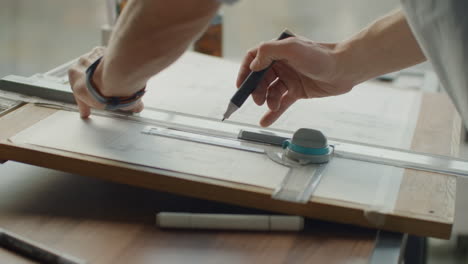 a male architect creates a drawing of a building on paper. to study the design of premises to create furniture and houses. large modern office draw on blackboard.