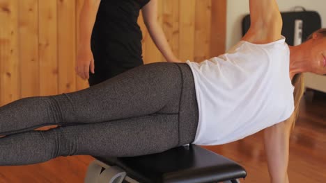 female trainer assisting woman with exercise