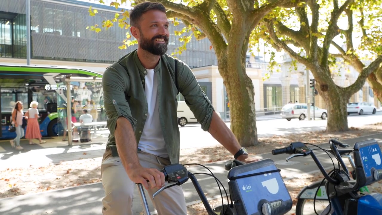 Man Using Smartphone to Unlock Rental Bicycle in City