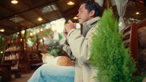 man taking photos of a cat in a cafe