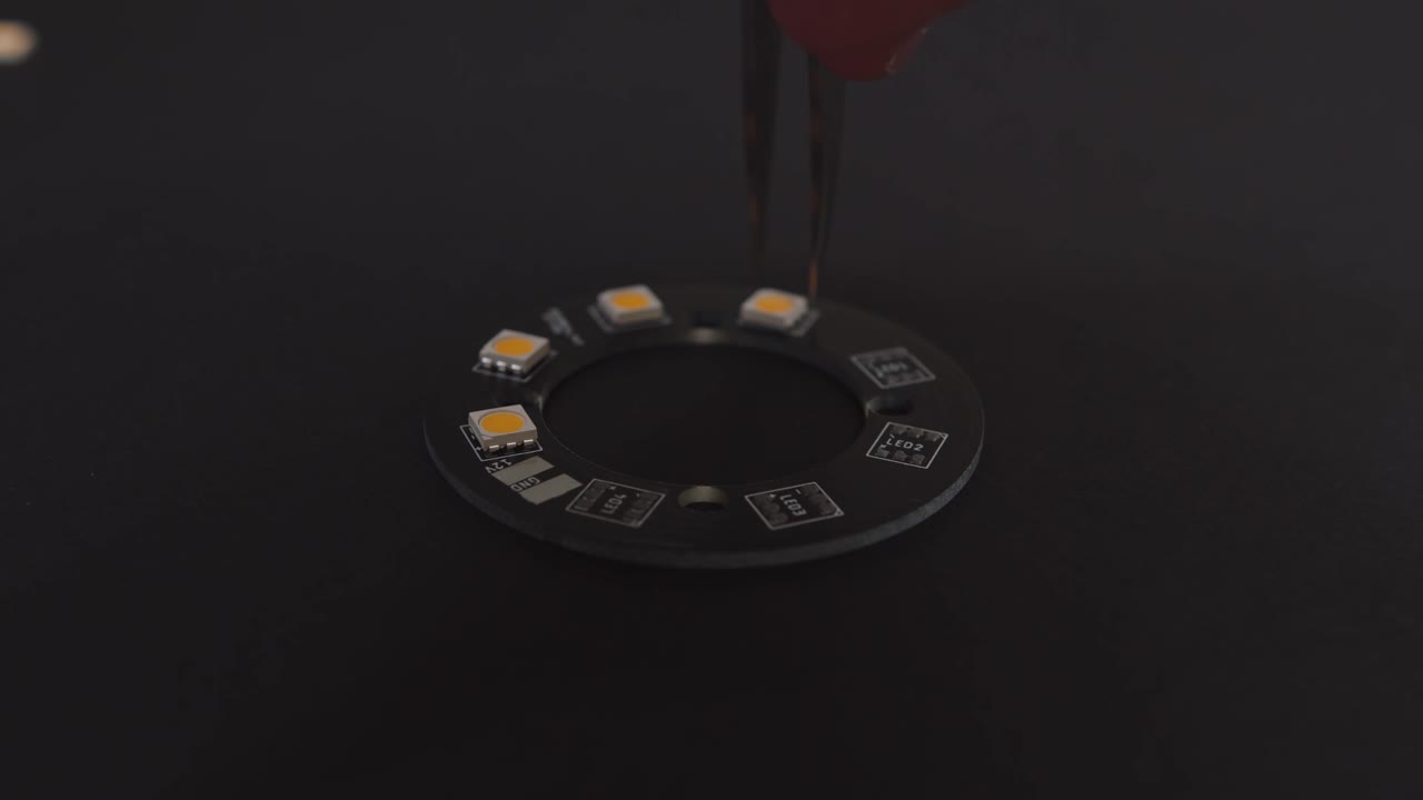 핀셋으로 led를 검은색 pcb 프로토타입에 수동으로 배치