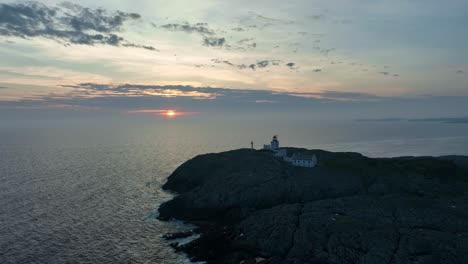 Marsteinen-Lighthouse-at-sunset,-capturing-ocean,-waves-and-the-lighthouse-with-sunset-background