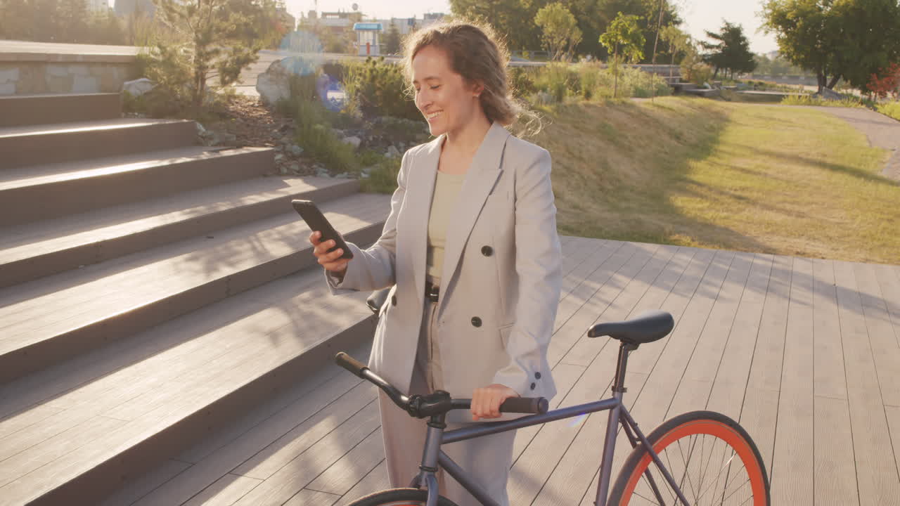 Business Woman with Bike Using Smartphone Outdoors