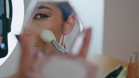 satisfied lady putting foundation using brush close up. woman applying cosmetics