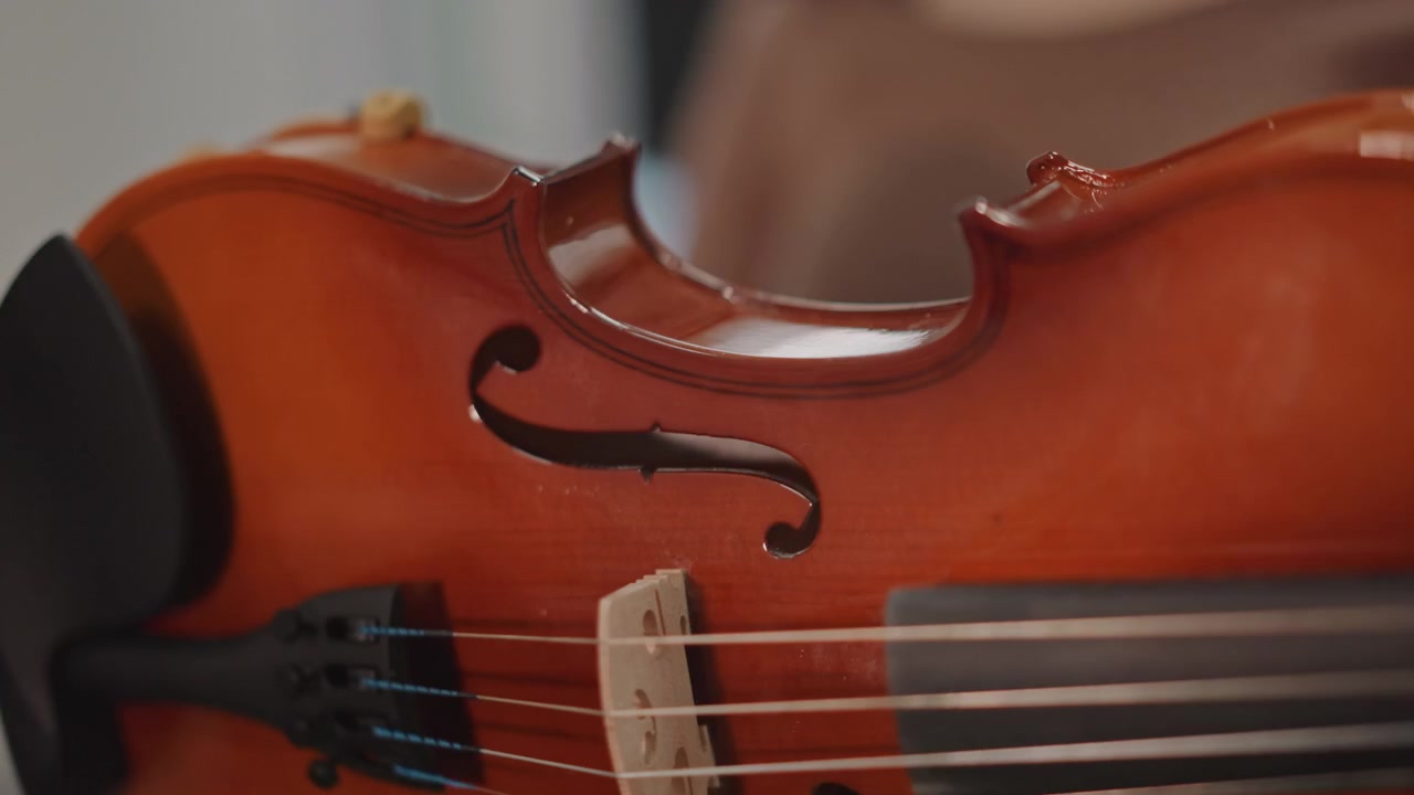 Instructor demonstrates bow posture. Focused violin instruction with collaborative practice atmosphere. Teacher and student work together demonstrating proper technique and posture in studio