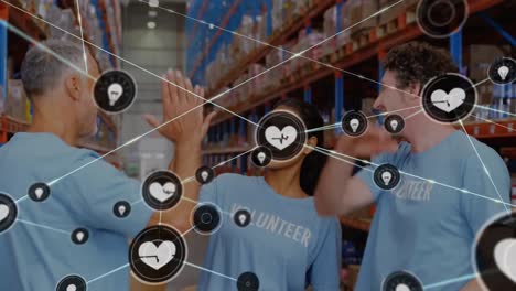 Animation-of-network-of-connections-with-icons-over-diverse-volunteers-working-in-warehouse