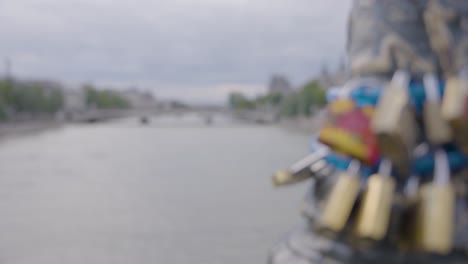 enfoque de rack de un montón de cerraduras en un puente de cerradura en parís, con vistas al río sena