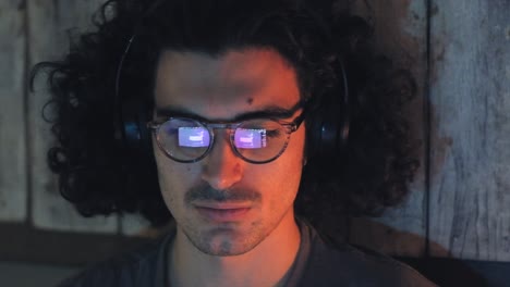 hombre usando computadora con gafas reflexión con auriculares