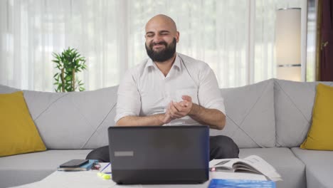 Ein-Mann,-Der-Im-Home-Office-Arbeitet,-Applaudiert-Dem,-Was-Er-Auf-Dem-Laptop-Sieht.